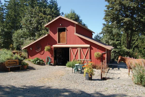 A red barn next to a paddock