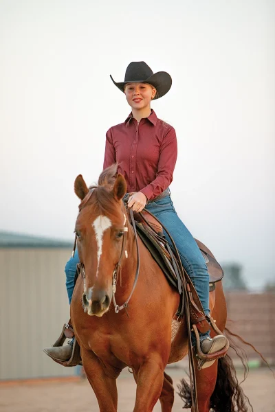 A young rider on a sorrel horse.