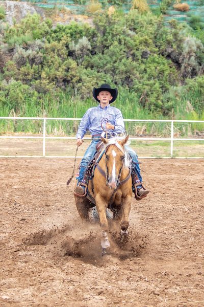 A young rider performs a reining sliding stop