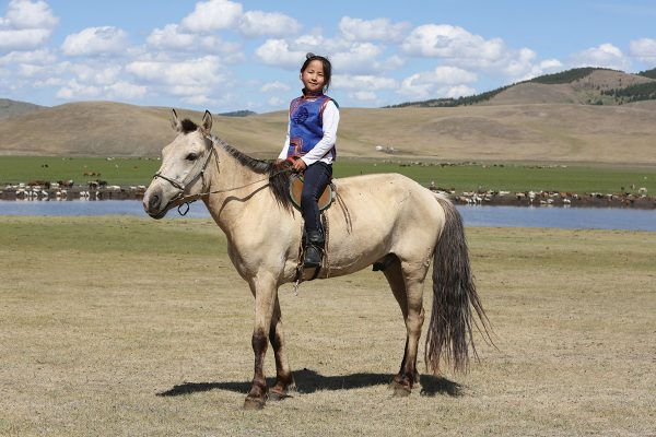 A young rider in Mongolia on a horse