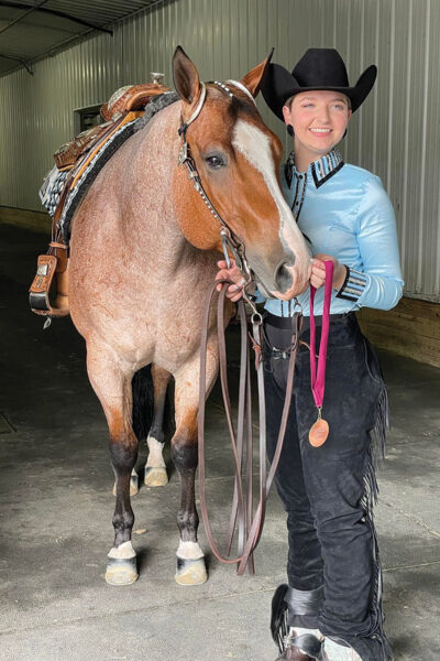 A young rider with her western show horse