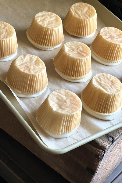 Cupcakes placed upside down on parchment paper on a baking sheet