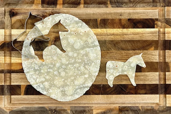A cutout of tortilla to make a horse-shaped chip.