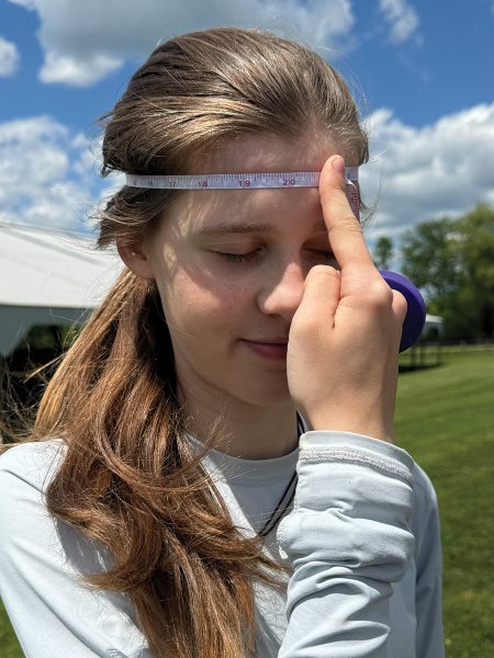 Measuring around the widest part of the head with a measuring tape.