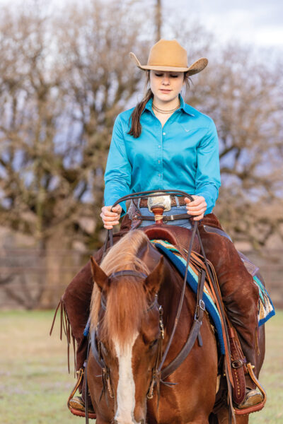 A girl rides her horse western