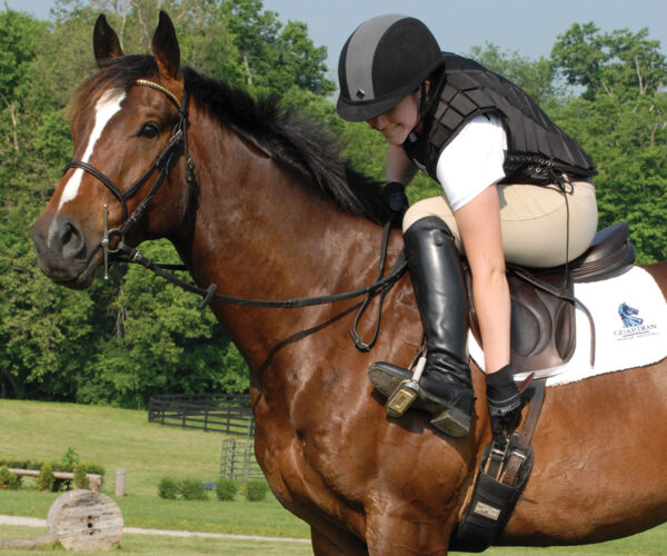 A rider checks her tack for safety