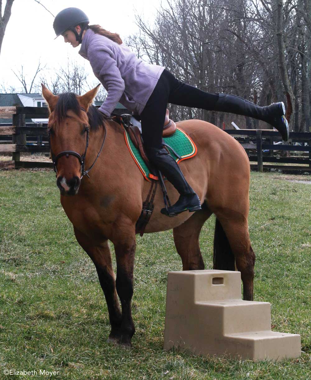 Rider mounting a horse from a mounting block