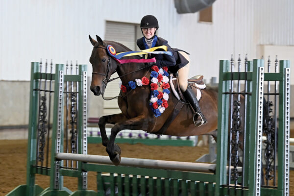 A champion equestrian jumps over a fence