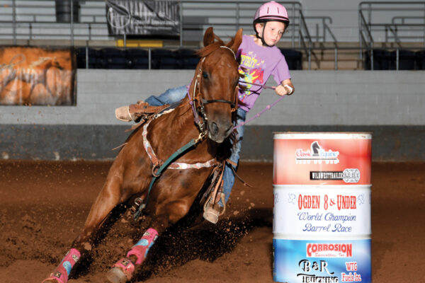 A young girl barrel racing