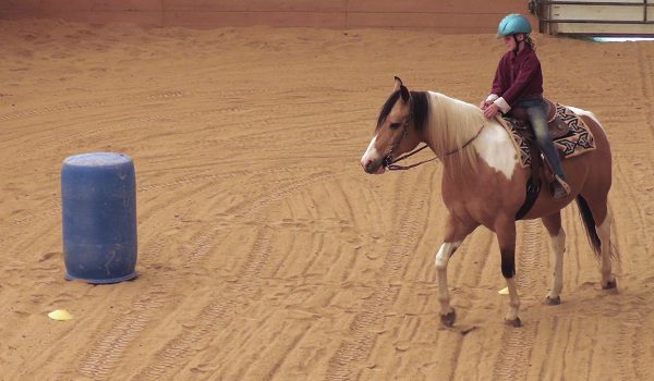 Rosie guides Chief with her inside rein around the first barrel.
