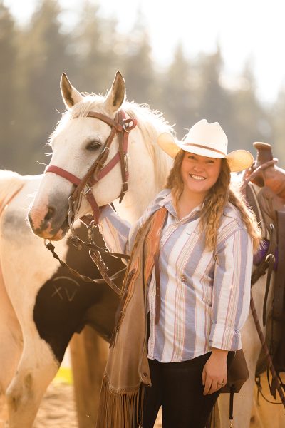 Showing an image of  A young cowgirl with a beautiful gray gelding.