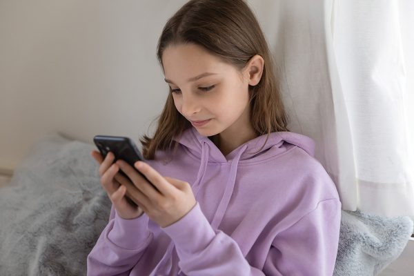 A girl watches a video on her phone