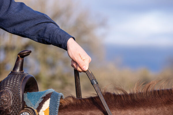 Demonstration of how to hold split reins with electrical tape showing the correct spot to hold them