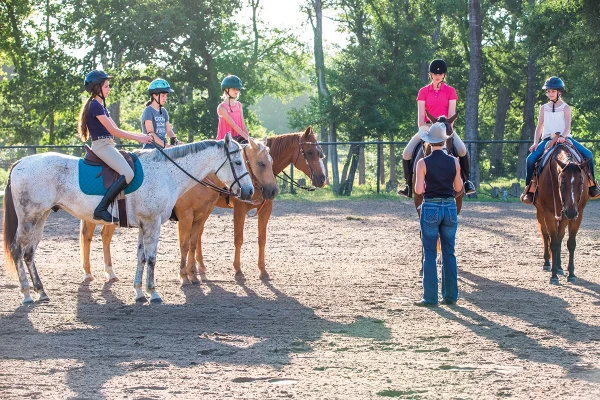 Young equestrians gathered for a riding lesson at summer horse camp.