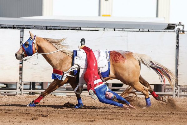 A girl performing a suicide drag at a rodeo