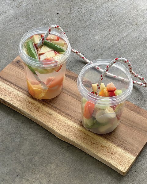 Cups filled with fruits and veggies to make DIY horsey popsicles.