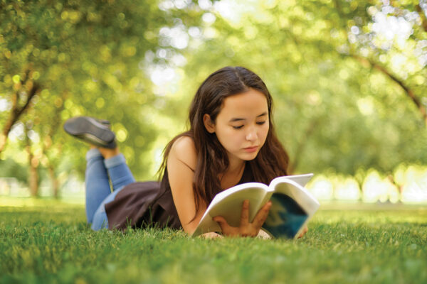 A girl reading a book in a park