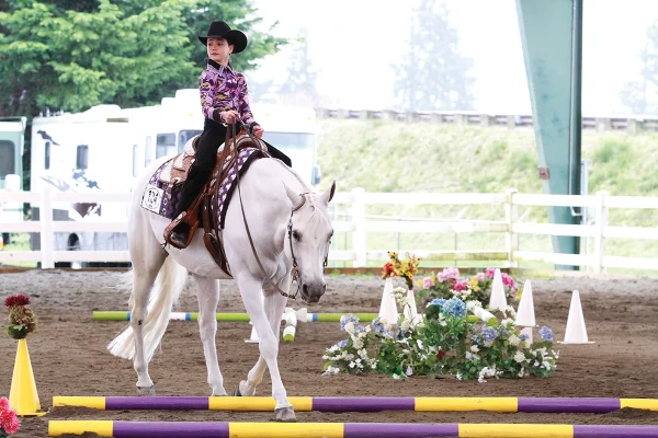 A young equestrian competing in a trail class.