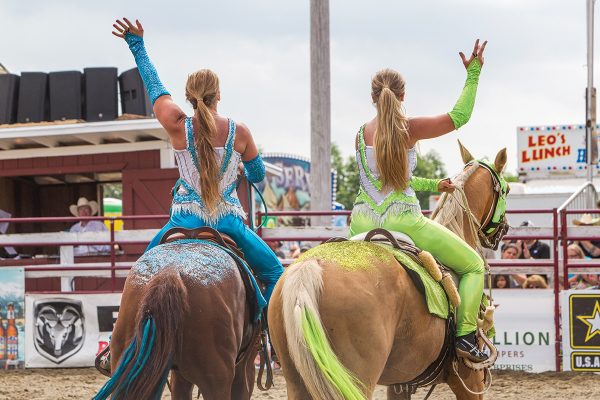 Rodeo performers wave to the crowd