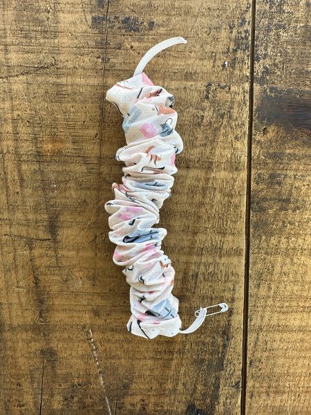 The fabric placed on the elastic to form a DIY horsey hair scrunchie.