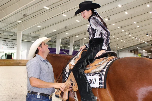 A trainer talks to a student at her first horse show.