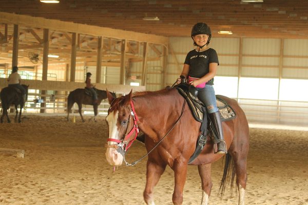 Lauren smiles while riding Socks at Camp Liberty.