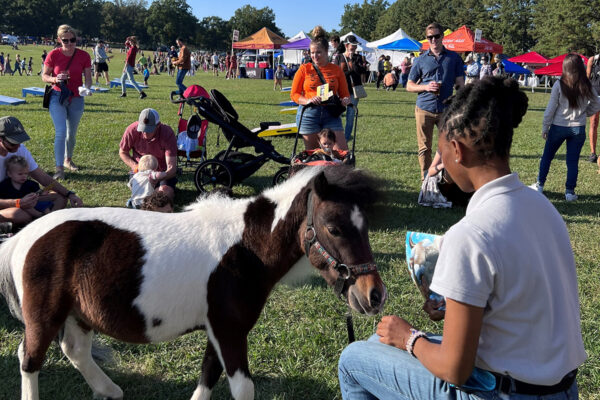 Caitlin Gooch, recipient of the ASPCA Equine Welfare Award, at an event with a mini horse and youth