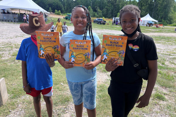 Youth of Saddle Up holding up books