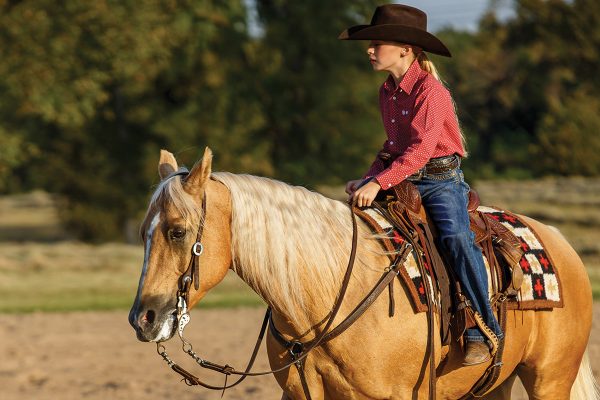 A young rider rides her horse on a loose rein