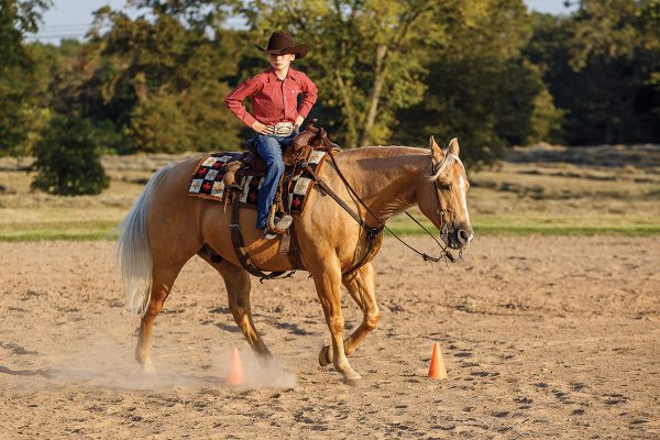 A young rider practices a drill with no hands