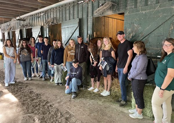 Members of Amplify Horse Racing, a youth horse racing organization, meet a racehorse.