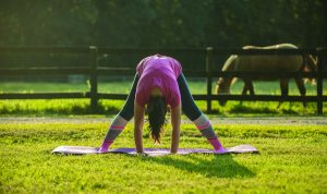 Person practicing yoga forward fold.